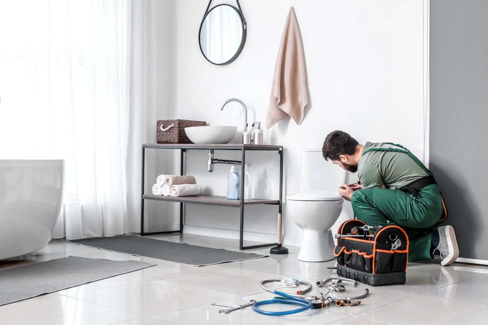 man plumbing a toilet